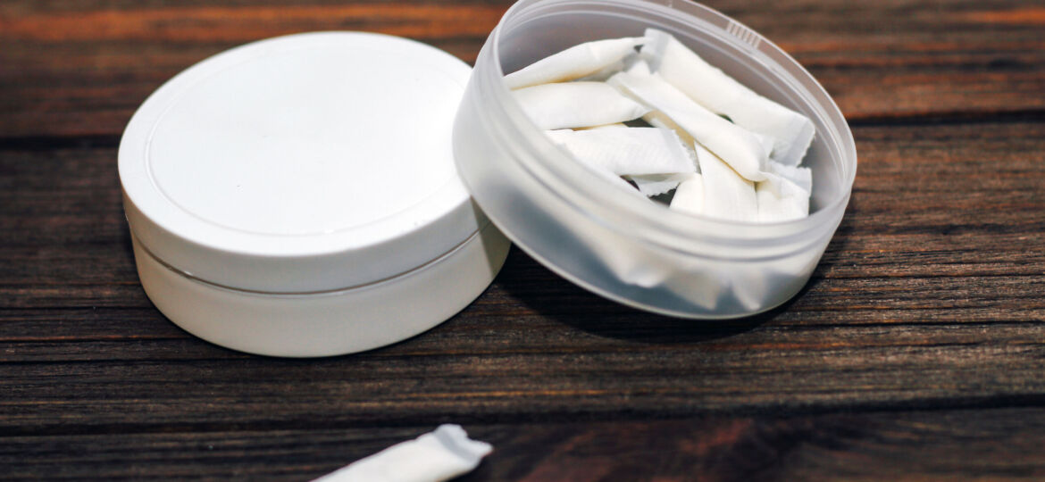 Snus box with nicotine pouches on wooden background