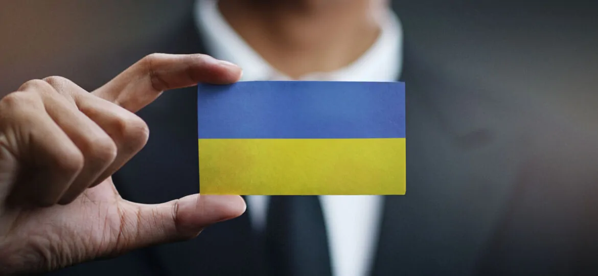 Businessman Holding Card of Ukraine Flag